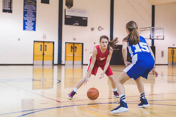 weibliche high-school-basketballspielerin dribbelt zu reifen - school gymnasium gym basketball court school stock-fotos und bilder