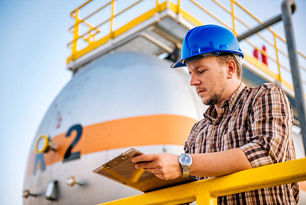 Man writing notes in the factory Man making report  in natural gas factory liquefied petroleum gas photos stock pictures, royalty-free photos & images