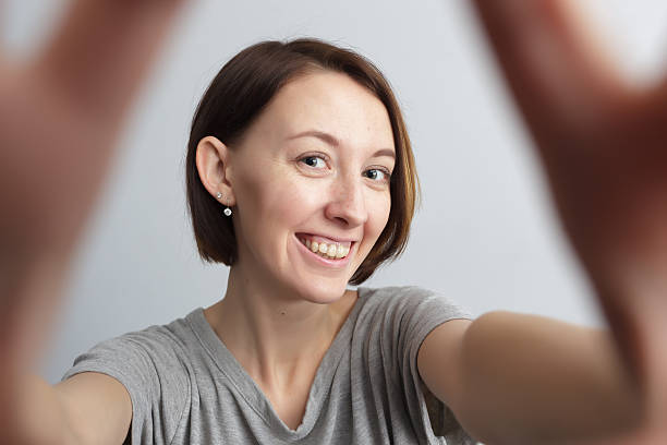 istock Smiling cheerful girl with freckles doing selfie. 637070854