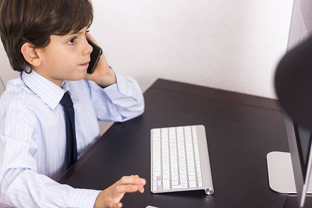 business boy with mobile phone and laptop in office - paying children only retail childhood imagens e fotografias de stock