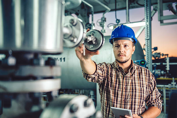 homem usando tablet em instalação de processamento de gás natural - chemical plant refinery industry pipe - fotografias e filmes do acervo