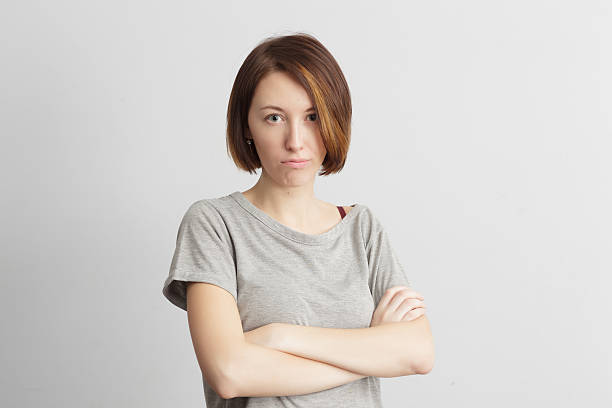 istock Girl with distrust and doubt looks forward, arms crossed ove 637074212