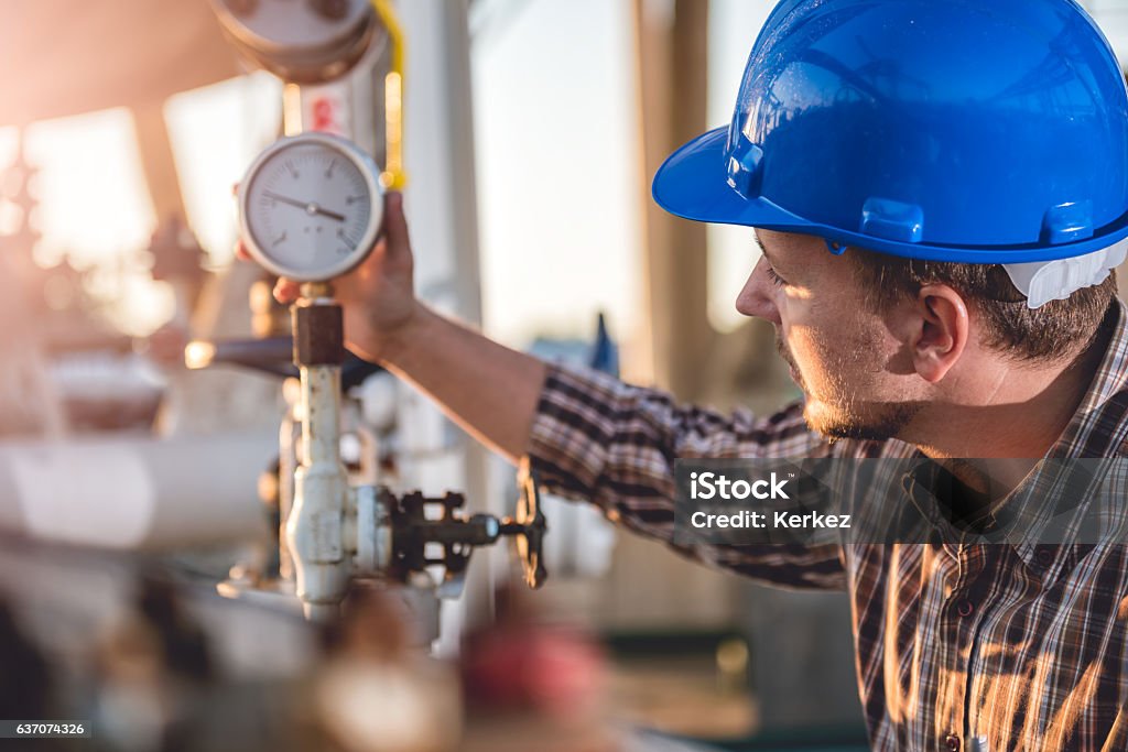 Man checking manometer Man checking manometer in natural gas factory Natural Gas Stock Photo