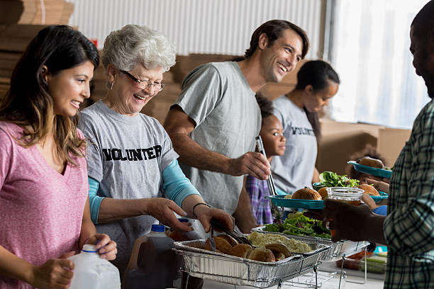 diversos grupos de voluntarios sirven comidas en refugios para personas sin hogar - homelessness men white black fotografías e imágenes de stock