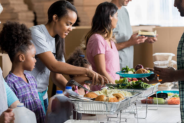 istock African American mom volunteers with daughters in soup kitchen 637078368