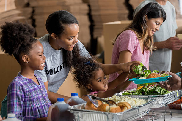 istock African American mom and daughters volunteer in soup kitchen 637078374
