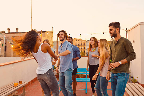 istock Happy friends dancing at the rooftop party 637078454