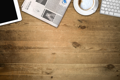 Daily newspaper and tablet pc on the wooden table. Text generated Lorem ipsum.