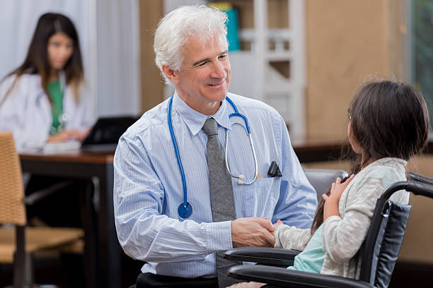 istock Young wheelchair-bound patient talks with her pediatrician 637078628