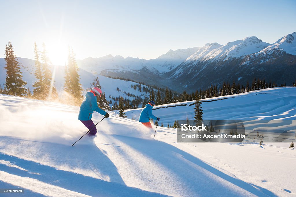 Casal esquiando em um dia ensolarado de pó - Foto de stock de Esqui - Esqui e snowboard royalty-free