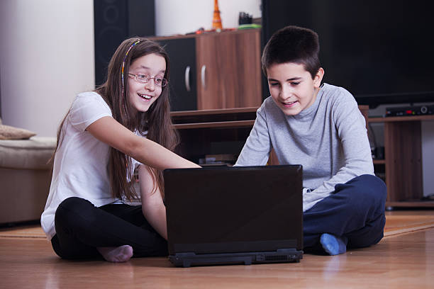 istock Brother and sister having fun with laptop 637084972