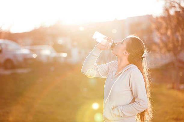 istock young sportive woman drinking water at sunset 637085540