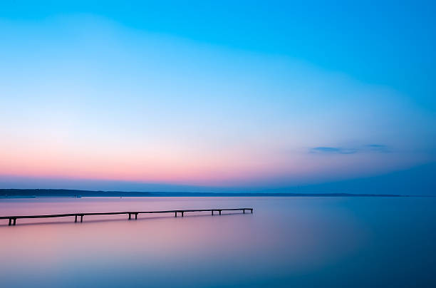 istock Old wooden pier on a lake at sunrise 637085582