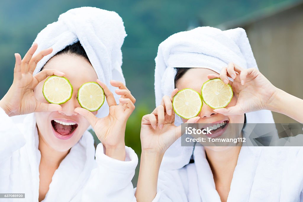 schöne Frau zeigt frische Zitrone im Spa - Lizenzfrei Weibliche Freundschaft Stock-Foto