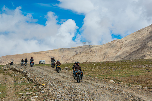 Changthang, India - July 21, 2015: A group of touristic motorbiker from Europe are riding with the local Royal Enfield motorbikes at the Changthang Plateau, Ladakh, India. They are crossing a upaved pass road in approx. 4800 m on their way to Tso Moriri (lake) in the Ladakhi part of the Changthang Plateau (literally: northern plains) in Jammu and Kashmir in northern India. 