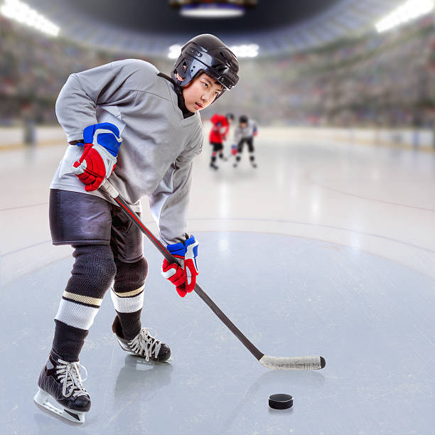 istock Junior Ice Hockey Player in Crowded Arena 637088578