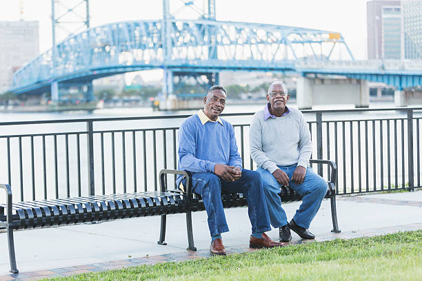 istock Two senior African American men on bench by waterfront 637089050