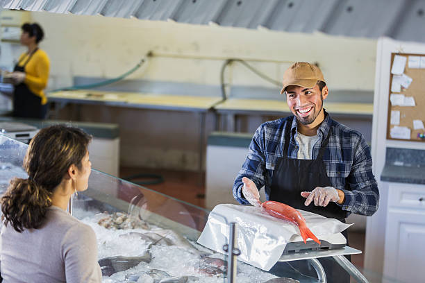 istock Worker in seafood market helping customer 637089898