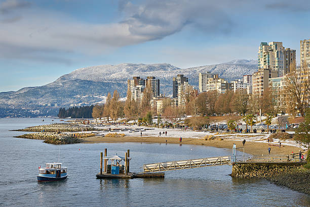 English Bay Winter, Vancouver Sunset Beach on English Bay. In the background are the snowcapped Coast Mountains. Vancouver, British Columbia, Canada. beach english bay vancouver skyline stock pictures, royalty-free photos & images