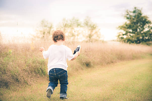 istock Little Boy Running in Field with one shoe 637092832