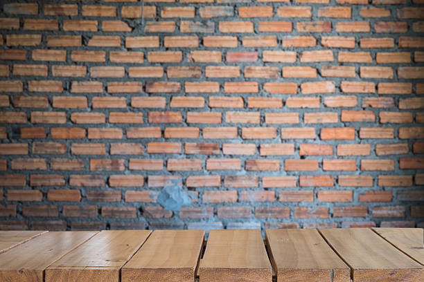 istock Empty top wood table and blur with wall red brick 637093310