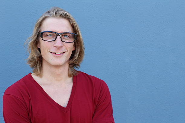 Portrait of casual blonde young man wearing glasses and red v-neck t-shirt.
