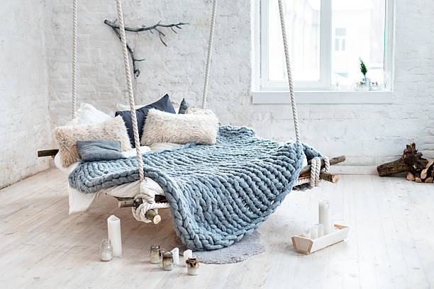 White loft interior in classic scandinavian style. Hanging bed suspended