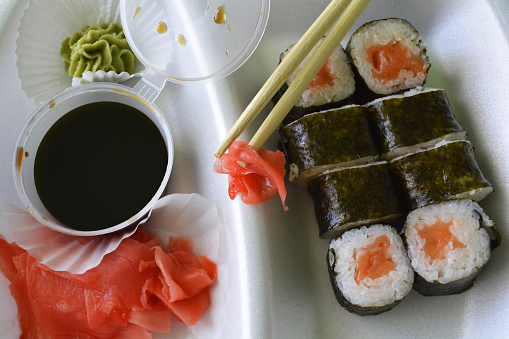 sushi rolls on plate with chopsticks, wasabi sauce and ginger