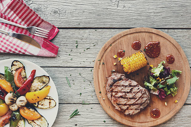 istock Grilled beef steak closeup on dark wooden table background 637119352
