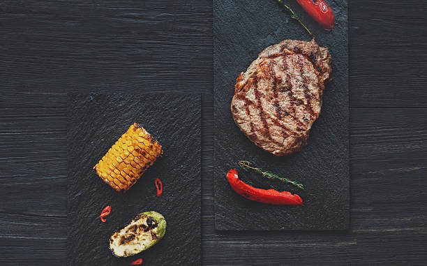 istock Grilled beef steak on dark wooden table background, top view 637119496