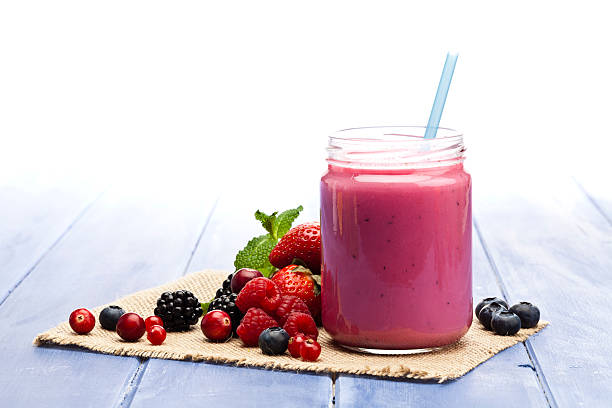 smoothie aux baies sur table bleue - healthy eating breakfast ripe fruit photos et images de collection