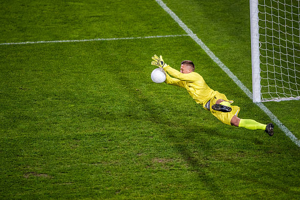 Goalkeeper diving Soccer goalie diving to block the ball. defending sport stock pictures, royalty-free photos & images