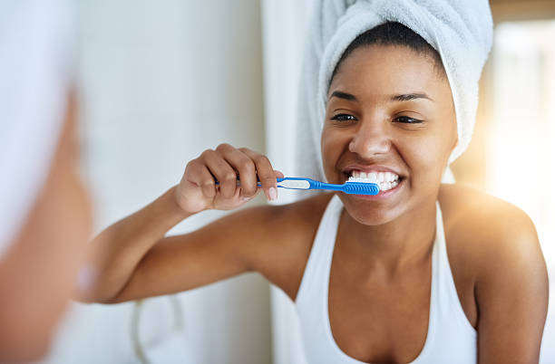 good oral hygiene begins every morning - brushing teeth women toothbrush brushing imagens e fotografias de stock