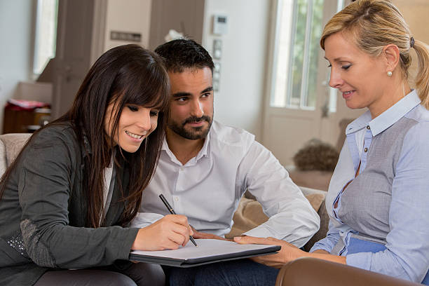 istock young couple signing contract with agent 637130462