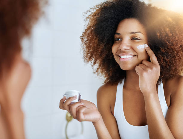 making the health of her skin a priority - mirror women bathroom make up imagens e fotografias de stock