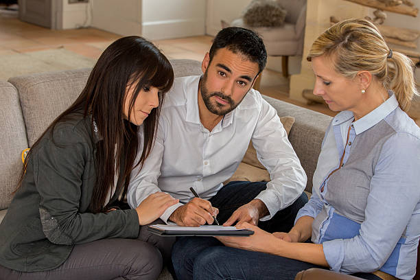 istock young couple signing contract with agent 637130706