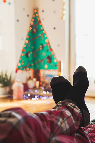 istock Feet with socks with Christmas gift boxes under the tree 637131300