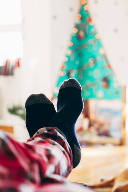 istock Feet with socks with Christmas gift boxes under the tree 637132092