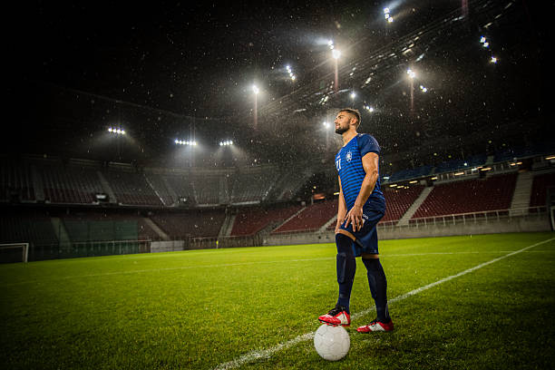 istock Football player standing in stadium 637137608