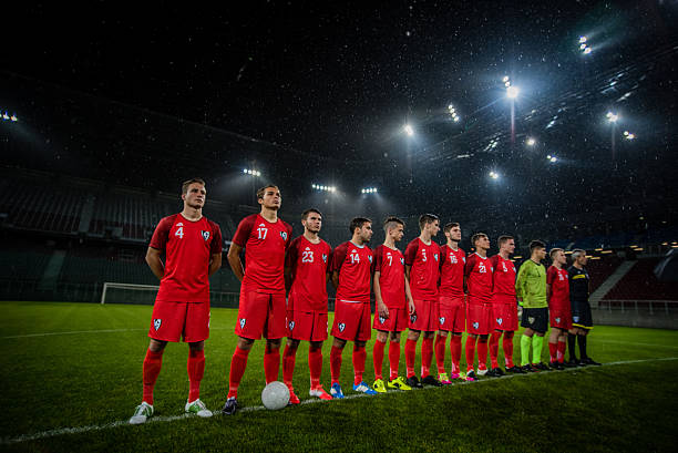 Football team in a row Football team standing in a row during national anthem before match. national anthem stock pictures, royalty-free photos & images