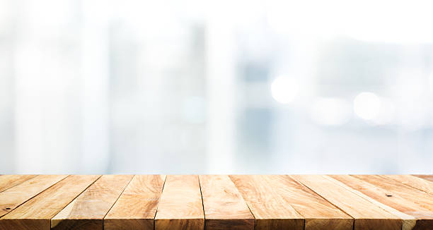 istock Wood table top on blur glass window wall background. 637139038