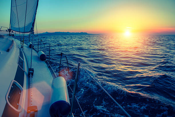 istock Sailing yacht glides at twilight on water surface 637140522