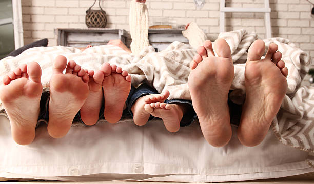 feet happy family a cute feet happy family bed human foot couple two parent family stock pictures, royalty-free photos & images