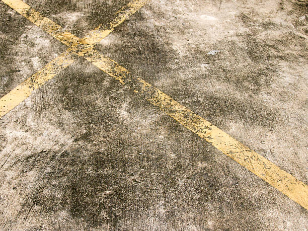 istock Grunge yellow line cross on stained concrete background 637145338