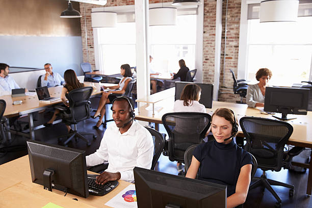 View Of Staff In Busy Customer Service Department View Of Staff In Busy Customer Service Department outsourcing stock pictures, royalty-free photos & images