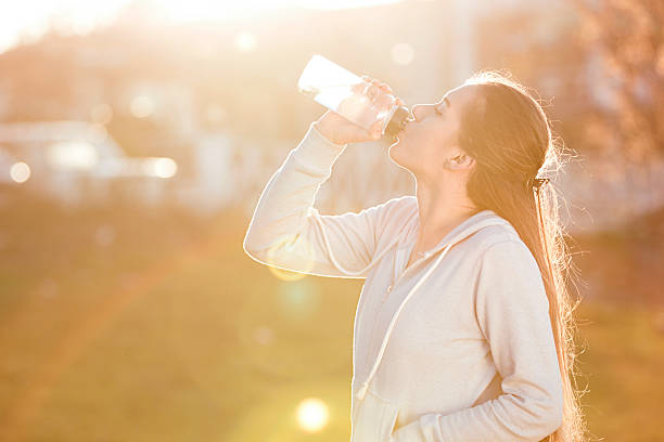 istock young sportive woman drinking water at sunset 637152170