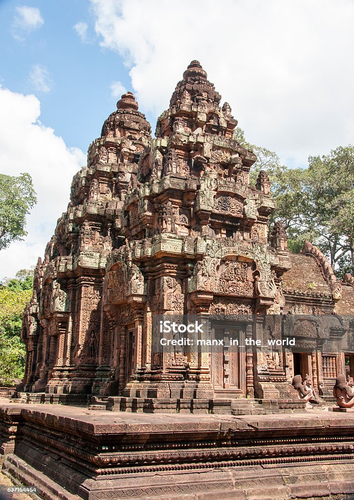 Famous Banteay Srei in Angkor. Asia, Cambodia, Siem Reap.  Banteay Srei (Citadel of Women)  is  a 10th century Hindu temple dedicated to Shiva. The red sandstone building The temple was rediscovered only in 1914 in the jungle as a part of the Angkor area, Siem Reap, Cambodia.  The temple, richly decorated with carvings is guarded  by statues : Narasimha and Hanuman and Garuda... Angkor Stock Photo