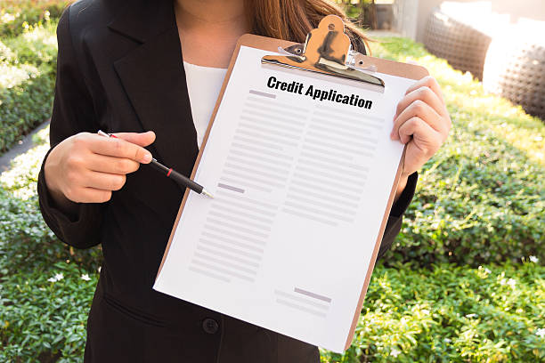 Women in suit showing approved credit application and pointing stock photo