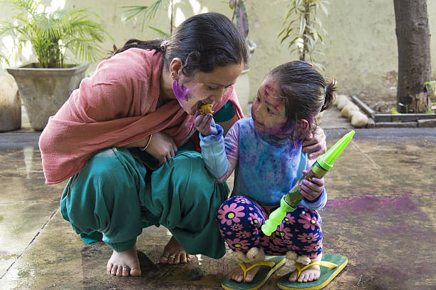 mother and daughter celebrating holi, the festival of colors. - facial expression child asia asian and indian ethnicities imagens e fotografias de stock