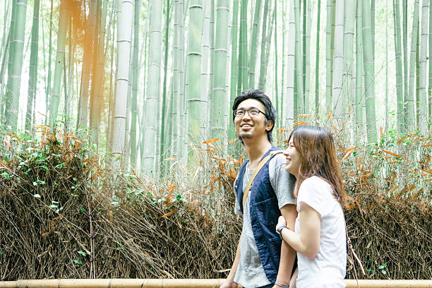istock Cheerful Japanese couple walking through bamboo forest 637161578